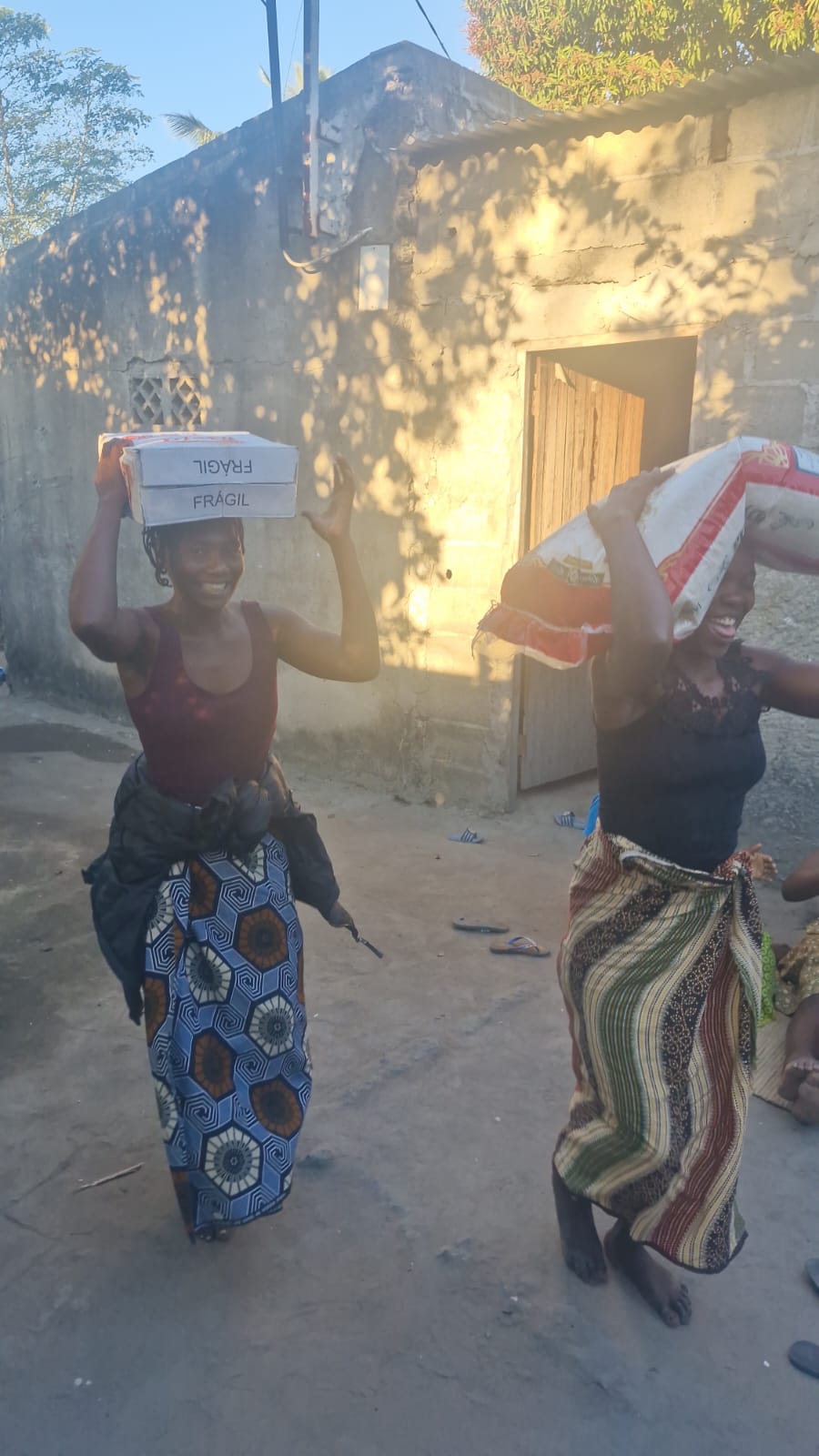 Luísa com o saco de arroz e Júlia com o alimento recebido no encontro